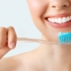 Frau hält Zahnbürste und lächelt
