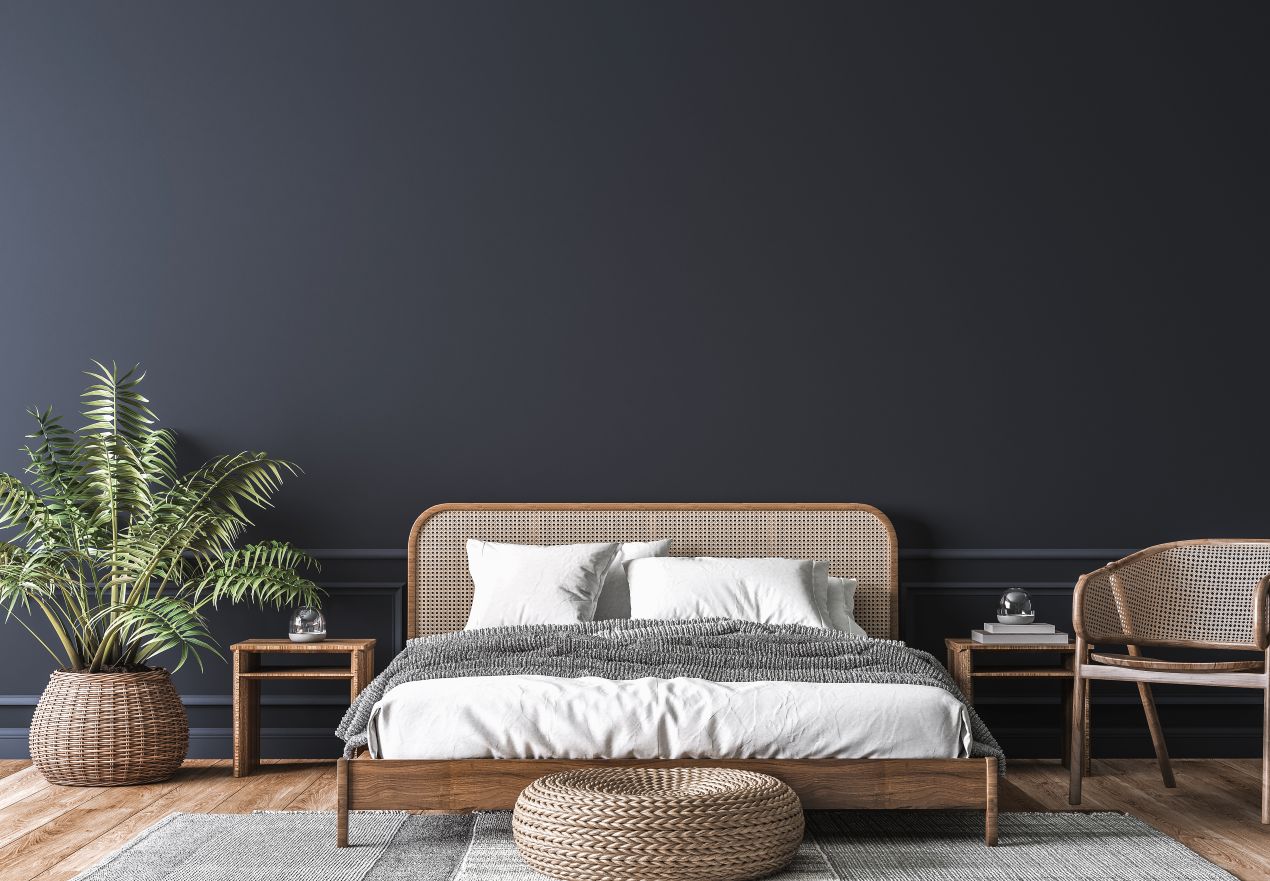 Dunkel eingerichtetes Schlafzimmer mit Rattanbett und weisser Bettwaesche – Einrichtungsidee zum Boxspringbett kaufen