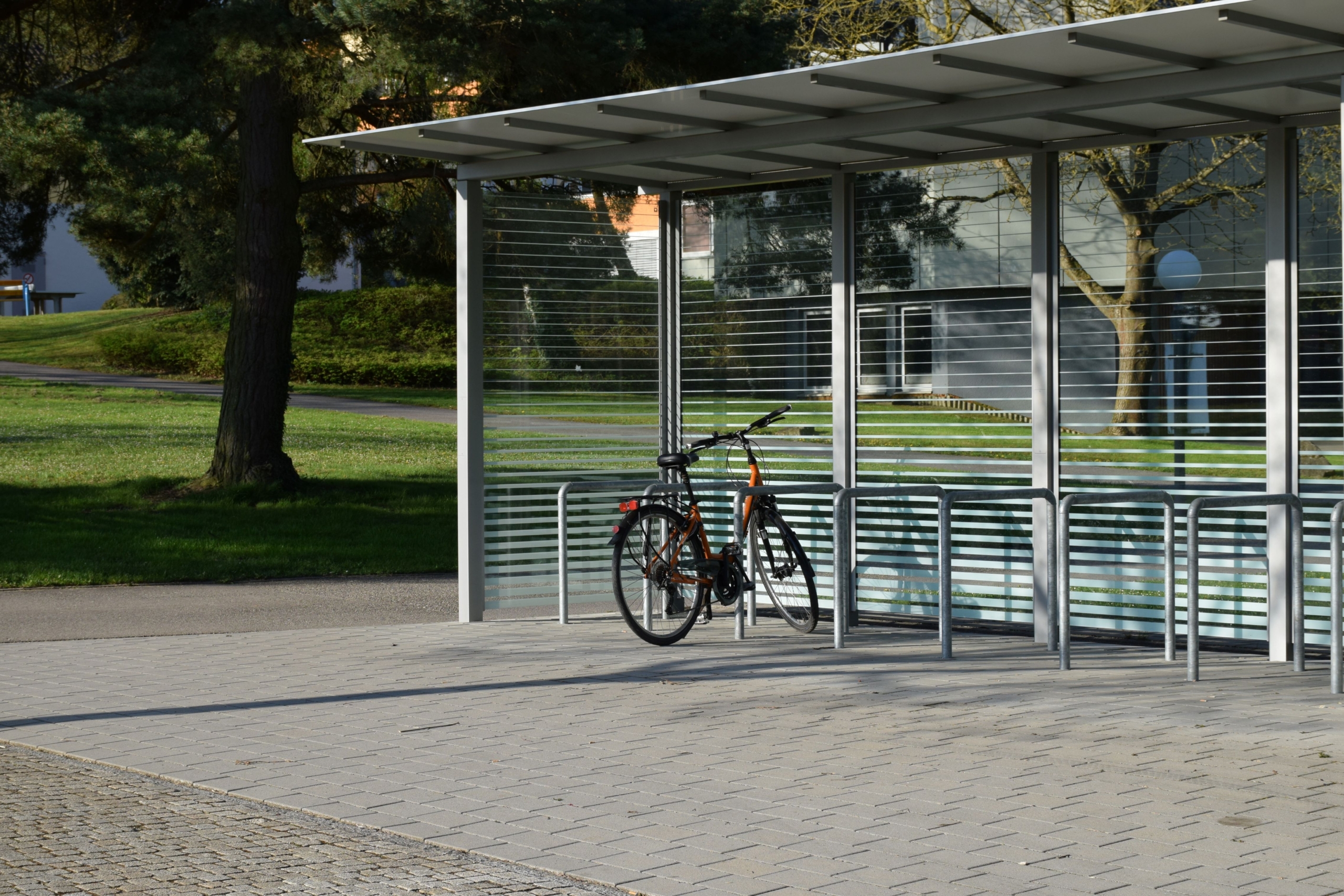 Fahrradüberdachung mit Seitenwänden, Anlehnbügeln und überdachten Stellplätzen im öffentlichen Raum
