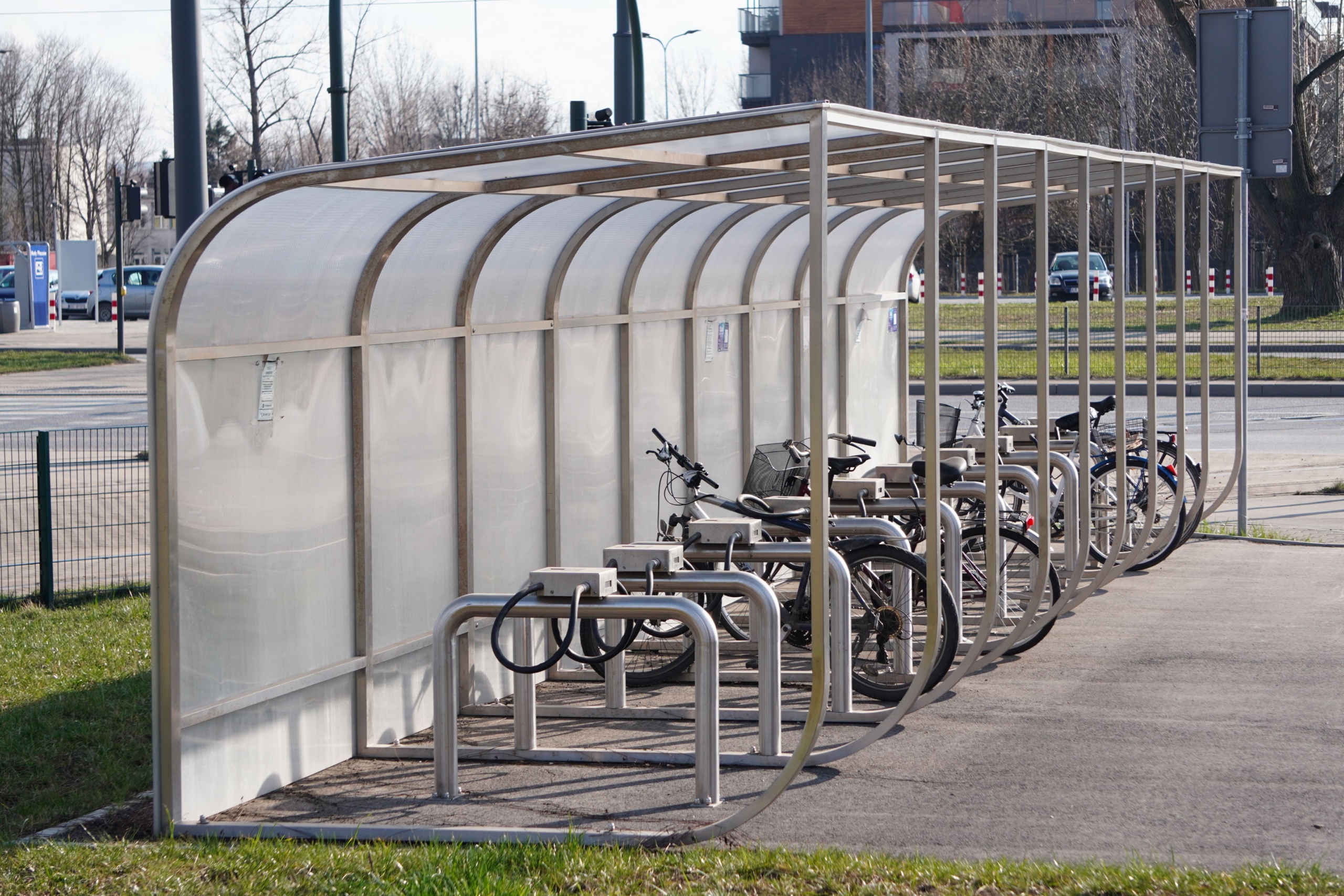 Reihung geparkter Fahrräder unter einer überdachten, seitlich geschlossenen Fahrradunterstellanlage
