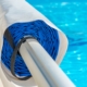 Poolabdeckung aufgerollt am Beckenrand neben klarem Wasser