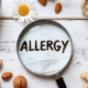 Allergie Symbol mit Nüssen, Ei und Lupe | Milchunverträglichkeit