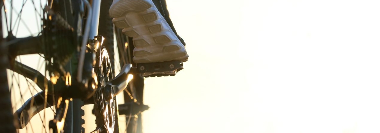 Nahaufnahme eines Fahrrads im Sonnenlicht mit Fokus auf Pedale – Symbol fuer Schutz und Ordnung durch eine Fahrradbox