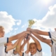 Kinder halten gemeinsam einen Pokal hoch als Zeichen für Teamgeist und Anerkennung im Sport